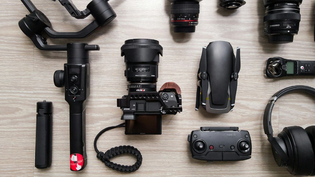 Flat lay of filmmaking equipment including a camera, tripod, boom microphone and headphones